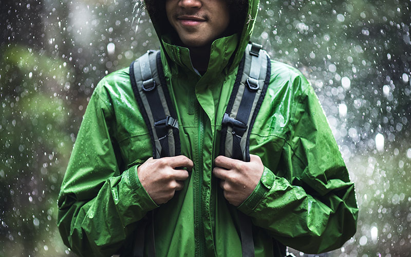 A man in a green waterproof raincoat