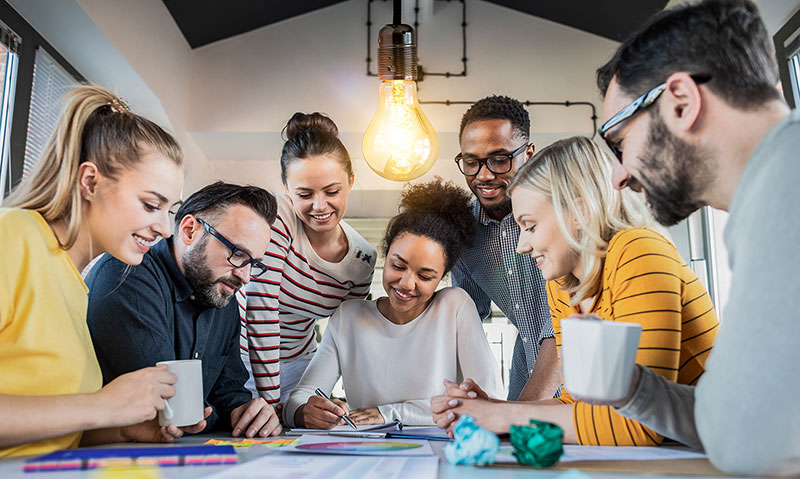 A group of people collaborating around a desk