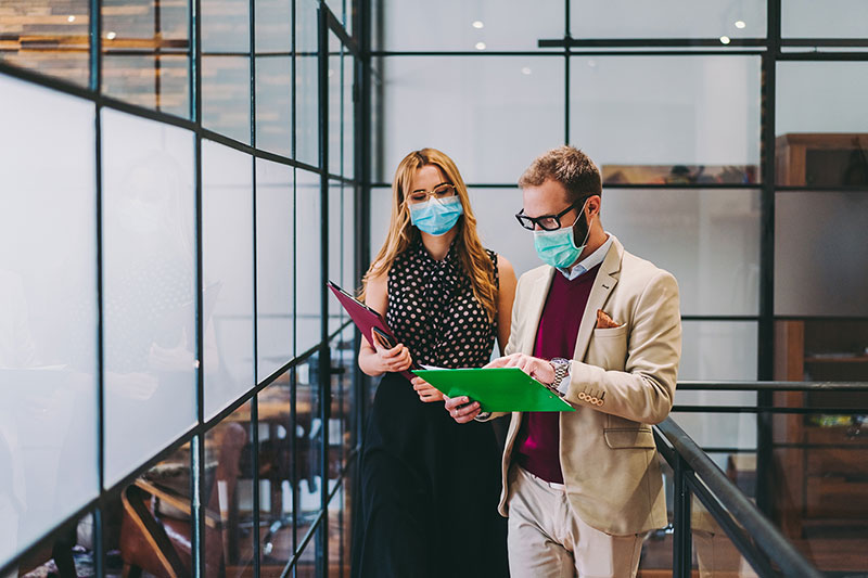 Two employees with clipboards in an office