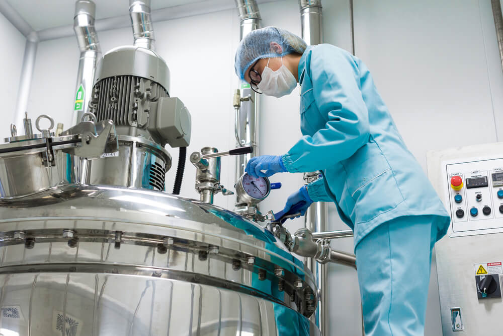 A worker checks on a chemical vat used for the blending of chemicals 
