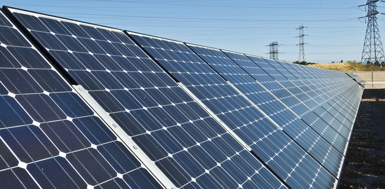 A large solar panel outside surrounded by blue sky.